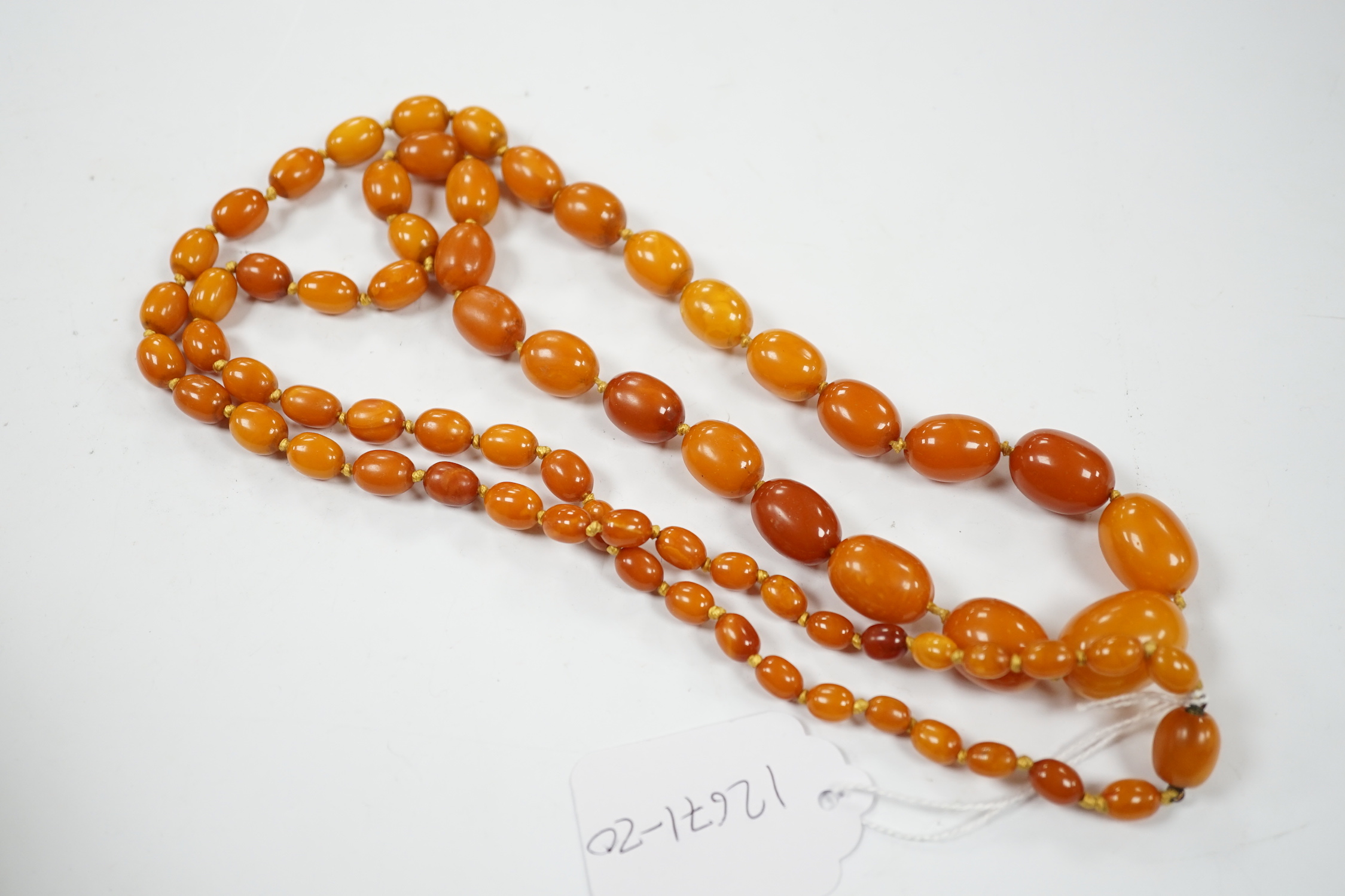 A single strand graduated oval amber bead necklace, 114cm, gross weight 84 grams.